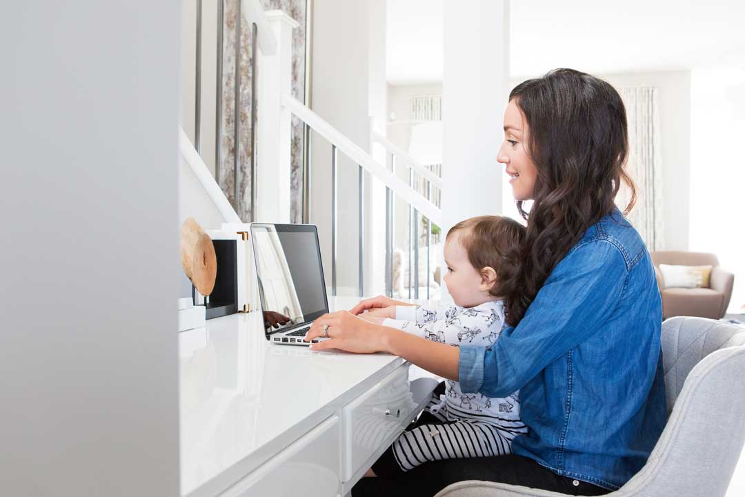 mom working from home with baby on her lap